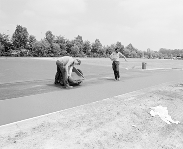 882356 Afbeelding van het leggen van een kunststoflaag op de Atletiekbaan Overvecht (1e Polderweg 7) te Utrecht.N.B. ...